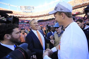 DENVER, CO - JANUARY 19:  John Elway, executive vice president of football operations for the Denver Broncos, celebrates with  Peyton Manning #18 after they defeated the New England Patriots 26 to 16 during the AFC Championship game at Sports Authority Fi