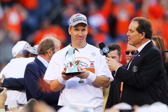 DENVER, CO - JANUARY 19:   Peyton Manning #18 of the Denver Broncos celebrates with the Lamar Hunt Trophy after they defeated the New England Patriots 26 to 16 in the AFC Championship game at Sports Authority Field at Mile High on January 19, 2014 in Denv