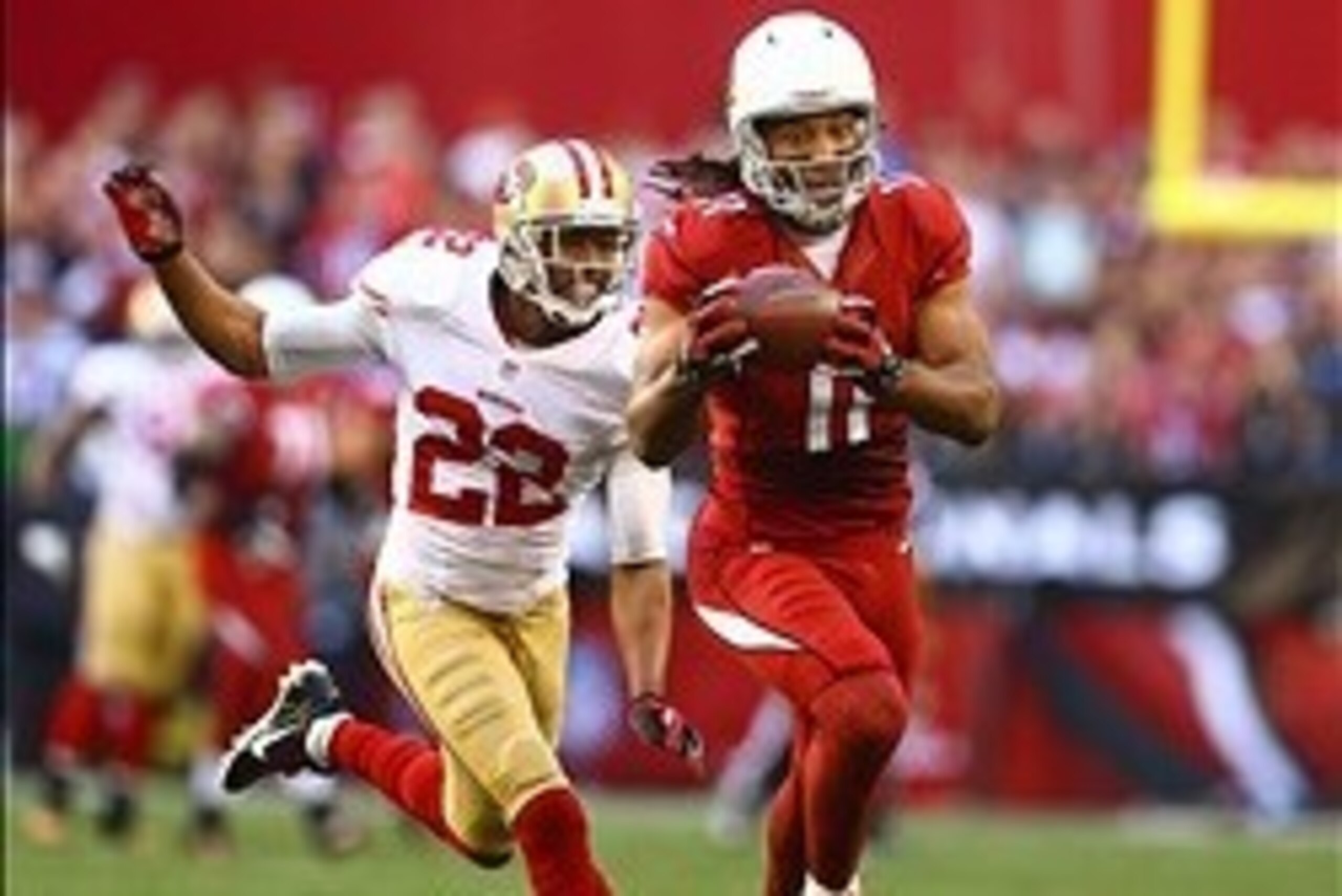 Dec 29, 2013; Phoenix, AZ, USA; Arizona Cardinals wide receiver Larry Fitzgerald (11) catches a pass under pressure from San Francisco 49ers cornerback Carlos Rogers (22) in the second quarter at University of Phoenix Stadium. Mandatory Credit: Mark J. Re