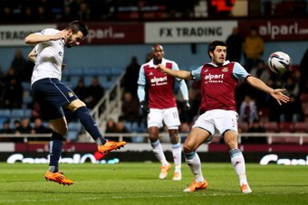 LONDON, ENGLAND - JANUARY 21:  Alvaro Negredo of Manchester City (L) beats James Tomkins of West Ham United (R) to score their first goal during the Capital One Cup Semi-Final, Second Leg match between West Ham United and Manchester City at Boleyn Ground 