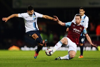 LONDON, ENGLAND - JANUARY 21:  Sergio Aguero of Manchester City is tackled by Kevin Nolan of West Ham United during the Capital One Cup Semi-Final, Second Leg match between West Ham United and Manchester City at Boleyn Ground on January 21, 2014 in London