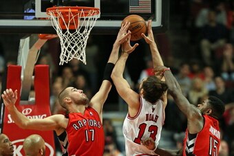 CHICAGO, IL - DECEMBER 14:  Jonas Valanciunas #17 of the Toronto Raptors blocks a shot by Joakim Noah #13 of the Chicago Bulls as Amir Johnson #15 defends at the United Center on December 14, 2013 in Chicago, Illinois. NOTE TO USER: User expressly acknowl