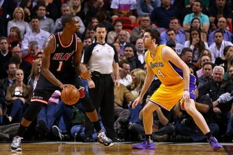 MIAMI, FL - JANUARY 23: Chris Bosh #1 of the Miami Heat posts up Ryan Kelly #4 of the Los Angeles Lakers during a game  at American Airlines Arena on January 23, 2014 in Miami, Florida. NOTE TO USER: User expressly acknowledges and agrees that, by downloa