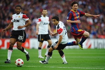 LONDON, ENGLAND - MAY 28:  Luis Antonio Valencia of Manchester United (L) and teammate Fabio da Silva  (C) look on as Lionel Messi of FC Barcelona (R) takes a shot during the UEFA Champions League final between FC Barcelona and Manchester United FC at Wem