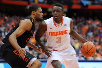 SYRACUSE, NY - JANUARY 04:  Jerami Grant #3 of the Syracuse Orange drives to the basket around the defense of Donnavan Kirk #22 of the Miami Hurricanes during the second half at the Carrier Dome on January 4, 2014 in Syracuse, New York.  Syracuse defeated