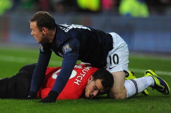 CARDIFF, WALES - NOVEMBER 24:  Manchester United player Wayne Rooney (r) clashes with Jordon Mutch for a challenge which Rooney is booked during the Barclays Premier League match between Cardiff City and Manchester United at Cardiff City Stadium on Novemb