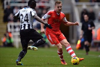 NEWCASTLE UPON TYNE, ENGLAND - DECEMBER 14:  Cheick Tiote of Newcastle United tackles Luke Shaw of Southampton during the Barclays Premier League match between Newcastle United and Southampton at St James' Park on December 14, 2013 in Newcastle upon Tyne,