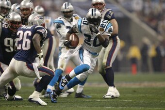 HOUSTON - FEBRUARY 1:  Running back DeShaun #20 Foster of the Carolina Panthers evades cornerback Eugene Wilson #26 of the New England Patriots during Super Bowl XXXVIII at Reliant Stadium on February 1, 2004 in Houston, Texas.  The Patriots defeated the 