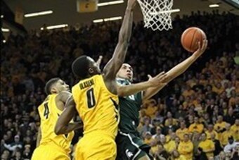 Jan 28, 2014; Iowa City, IA, USA; Iowa Hawkeyes forward Gabriel Olaseni (0) and guard Roy Devyn Marble (4) defends Michigan State Spartans guard Denzel Valentine (45) during the first half at Carver-Hawkeye Arena. Mandatory Credit: Reese Strickland-USA TO