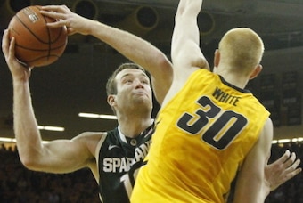 IOWA CITY, IA - JANUARY 28:  Forward Matt Costello #10 of the Michigan State Spartans goes to the basket during the second half against forward Aaron White #30 of the Iowa Hawkeyes on January 28, 2014 at Carver-Hawkeye Arena, in Iowa City, Iowa. (Photo by