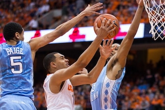 SYRACUSE, NY - JANUARY 11:  Tyler Ennis #11 of the Syracuse Orange puts in a lay up between defenders Marcus Paige #5 and J.P. Tokoto #13 of the North Carolina Tar Heels in the first half on January 11, 2014 at The Carrier Dome in Syracuse, New York. (Pho