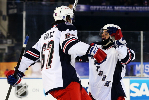 NEW YORK, NY - JANUARY 29:  (EDITORIAL USE ONLY)  Benoit Pouliot #67 of the New York Rangers celebrates his second period goal with teammate Mats Zuccarello #36 during the 2014 Coors Light NHL Stadium Series game against the New York Islanders at Yankee S