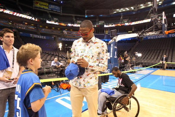 OKLAHOMA CITY, OK - JUNE 12: Russell Westbrook #0 of the Oklahoma City Thunder signs a hat for a young fan prior to the start against the Miami Heat in Game One of the 2012 NBA Finals at Chesapeake Energy Arena on June 12, 2012 in Oklahoma City, Oklahoma.