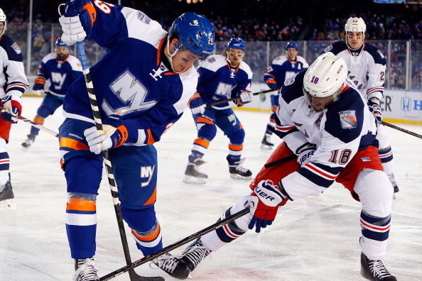 NEW YORK, NY - JANUARY 29:  (EDITORIAL USE ONLY)  Marc Staal #18 of the New York Rangers battles for the puck against Brock Nelson #29 of the New York Islanders during the 2014 Coors Light NHL Stadium Series at Yankee Stadium on January 29, 2014 in the Br