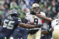 Jan 11, 2014; Seattle, WA, USA; New Orleans Saints quarterback Drew Brees (9) is tackled by Seattle Seahawks defensive end Cliff Avril (56) and defensive end Michael Bennett (72) during the second half of the 2013 NFC divisional playoff football game at C