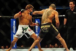 Jul 21, 2012; Calgary, AB, CANADA; Renan Barao (blue golves) and Urijah Faber (red gloves) during the interim bantamweight title bout of UFC 149 at the Scotiabank Saddledome. Mandatory Credit: Anne-Marie Sorvin-USA TODAY Sports