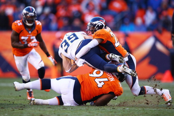 DENVER, CO - JANUARY 12:  Danny Woodhead #39 of the San Diego Chargers is tackled by Terrance Knighton #94 and Chris Harris #25 of the Denver Broncos during the AFC Divisional Playoff Game at Sports Authority Field at Mile High on January 12, 2014 in Denv