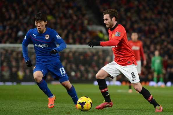 MANCHESTER, ENGLAND - JANUARY 28:  Juan Mata of Manchester United competes with Kim Bo-Kyung of Cardiff City during the Barclays Premier League match between Manchester United and Cardiff City at Old Trafford on January 28, 2014 in Manchester, England.  (