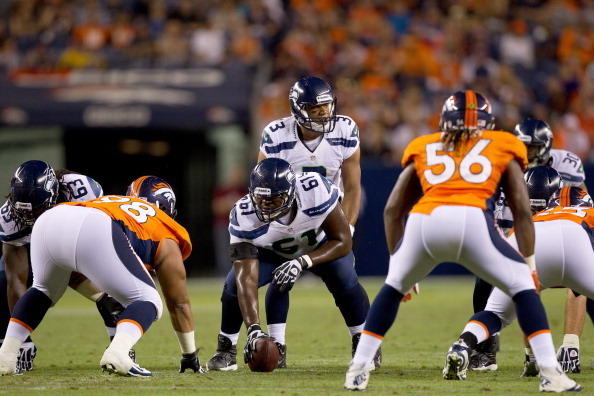 DENVER, CO - AUGUST 18:  Quarterback Russell Wilson #3 of the Seattle Seahawks audibles at the line of scrimmage as center Lemuel Jeanpierre #61 of the Seattle Seahawks prepares to hike the football during the fourth quarter against the Denver Broncos  at