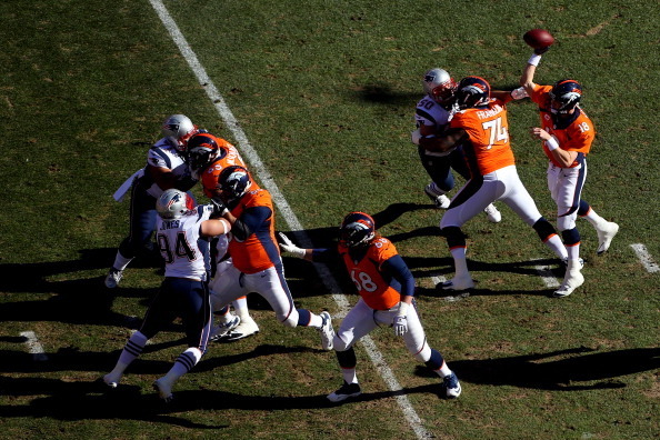 DENVER, CO - JANUARY 19:   Peyton Manning #18 of the Denver Broncos throws a pass against the New England Patriots during the AFC Championship game at Sports Authority Field at Mile High on January 19, 2014 in Denver, Colorado.  (Photo by Justin Edmonds/G