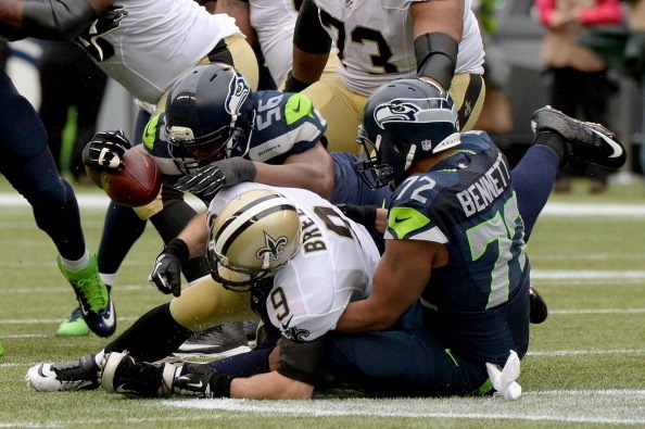 SEATTLE, WA - JANUARY 11:  Quarterback Drew Brees #9 of the New Orleans Saints is sacked by defensive end Cliff Avril #56 and defensive end Michael Bennett #72 of the Seattle Seahawks in the third quarter during the NFC Divisional Playoff Game at CenturyL