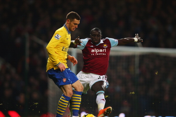 LONDON, ENGLAND - DECEMBER 26:  Thomas Vermaelen of Arsenal is challenged by Mohamed Diame during the Barclays Premier League match between West Ham United and Arsenal at Boleyn Ground on December 26, 2013 in London, England.  (Photo by Bryn Lennon/Getty 