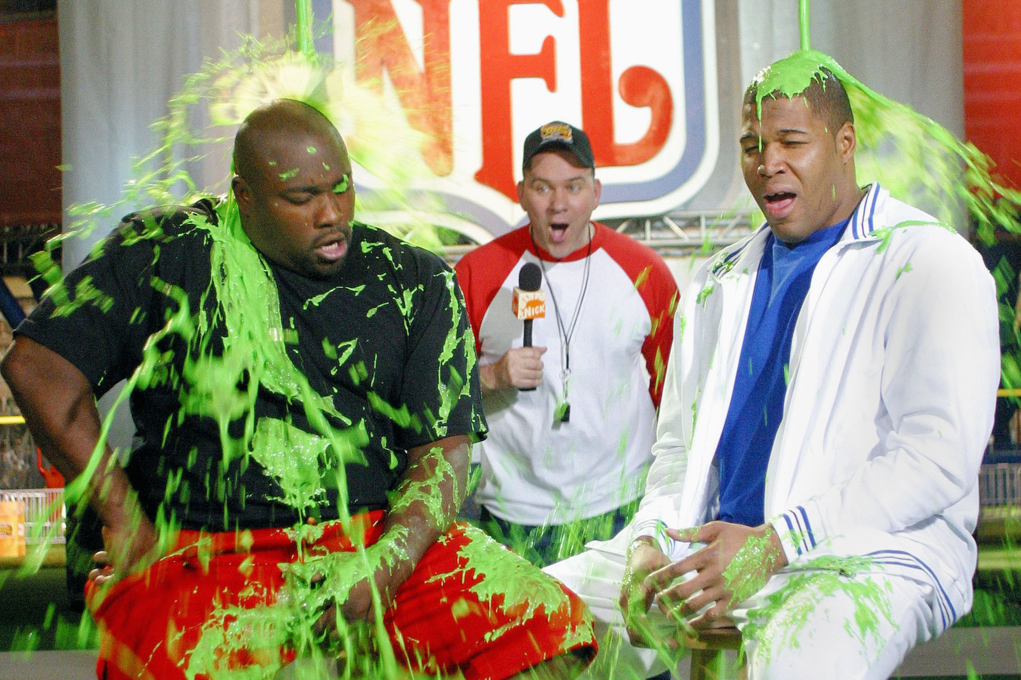 HOUSTON - JANUARY 29:  Mike O'Malley of CBS' 'Yes, Dear' looks on as Warren Sapp of the Tampa Bay Buccaneers and Michael Strahan of the NY Giants get slimed during the taping of 'Nickelodeon Takes Over The Super Bowl' January 29, 2004 in Houston.  (Photo