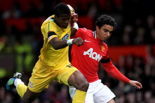 MANCHESTER, ENGLAND - NOVEMBER 30:  Fabio of Manchester United tussles for posession with Wilfried Zaha of Crystal Palace during the Carling Cup Quarter Final match between Manchester United and Crystal Palace at Old Trafford on November 30, 2011 in Manch