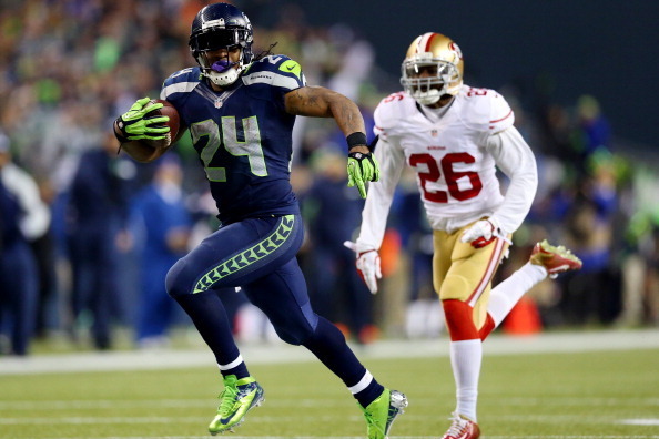 SEATTLE, WA - JANUARY 19:  Running back Marshawn Lynch #24 of the Seattle Seahawks scores a 40-yard touchdown against cornerback Tramaine Brock #26 of the San Francisco 49ers in the third quarter during the 2014 NFC Championship at CenturyLink Field on Ja