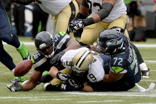 SEATTLE, WA - JANUARY 11:  Quarterback Drew Brees #9 of the New Orleans Saints is sacked by defensive end Cliff Avril #56 and defensive end Michael Bennett #72 of the Seattle Seahawks in the third quarter during the NFC Divisional Playoff Game at CenturyL