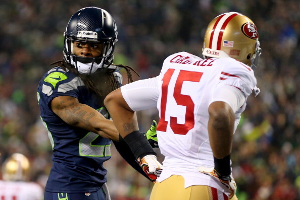 SEATTLE, WA - JANUARY 19:  Cornerback Richard Sherman #25 of the Seattle Seahawks talks with the referee after being called for an unsportsmanlike penalty for taunting wide receiver Michael Crabtree #15 of the San Francisco 49ers late in the fourth quarte