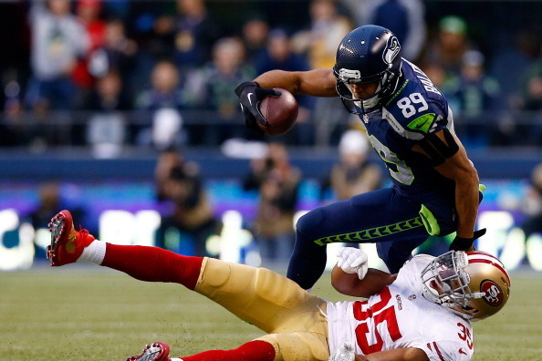 SEATTLE, WA - JANUARY 19: Wide receiver Doug Baldwin #89 of the Seattle Seahawks is tackled by free safety Eric Reid #35 of the San Francisco 49ers during the 2014 NFC Championship at CenturyLink Field on January 19, 2014 in Seattle, Washington.  (Photo b