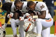 Oct. 6, 2012; Chicago, IL, USA; Miami Hurricanes linebacker Eddie Johnson (44), linebacker Denzel Perryman (52) and linebacker Gionni Paul (36) pray before the game against the Notre Dame Fighting Irish at Soldier Field. Notre Dame won 41-3. Mandatory Cre