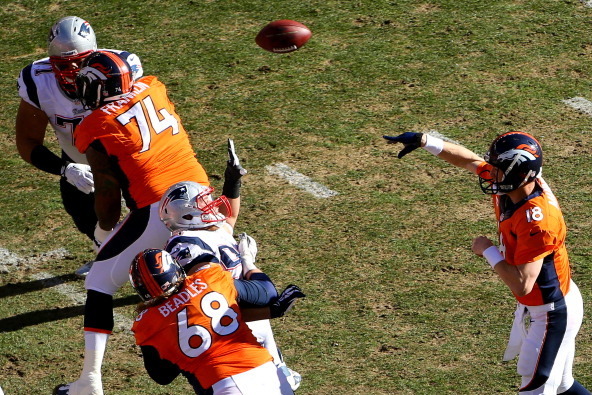 DENVER, CO - JANUARY 19:   Peyton Manning #18 of the Denver Broncos throws a pass against the New England Patriots during the AFC Championship game at Sports Authority Field at Mile High on January 19, 2014 in Denver, Colorado.  (Photo by Justin Edmonds/G