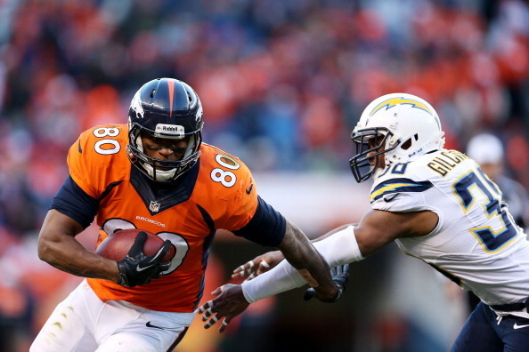 DENVER, CO - JANUARY 12:  Julius Thomas #80 of the Denver Broncos tries to avoid the tackle of  Marcus Gilchrist #38 of the San Diego Chargers during the AFC Divisional Playoff Game at Sports Authority Field at Mile High on January 12, 2014 in Denver, Col