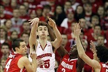 Feb 1, 2014; Madison, WI, USA; Wisconsin Badgers forward Sam Dekker (15) passes the ball as Ohio State guards Aaron Craft (4), Shannon Scott (3) and Amedeo Della Valle (right) defend during the first half at the Kohl Center. Mandatory Credit: Mary Langenf