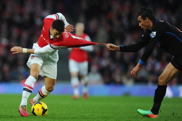 LONDON, ENGLAND - FEBRUARY 02:  Mesut Ozil of Arsenal has his shirt pulled by Marouane Chamakh of Crystal Palace during the Barclays Premier League match between Arsenal and Crystal Palace at Emirates Stadium on February 2, 2014 in London, England.  (Phot
