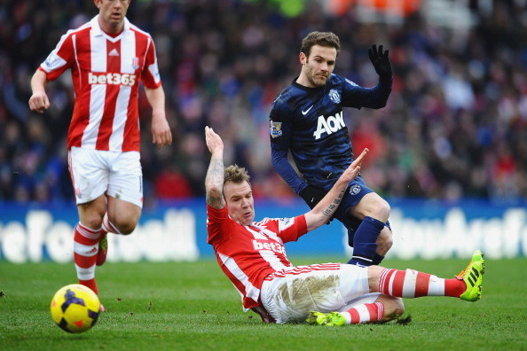 STOKE ON TRENT, ENGLAND - FEBRUARY 01: Juan Mata of Manchester United is challenged by Glenn Whelan of Stoke City during the Barclays Premier League match between Stoke City and Manchester United at Britannia Stadium on February 1, 2014 in Stoke on Trent,