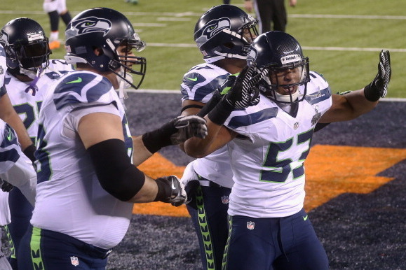 EAST RUTHERFORD, NJ - FEBRUARY 02:  Outside linebacker Malcolm Smith #53 of the Seattle Seahawks celebrates his 69-yard touchdown with teammates after intercepting a pass thrown by quarterback Peyton Manning #18 of the Denver Broncos intended for running 