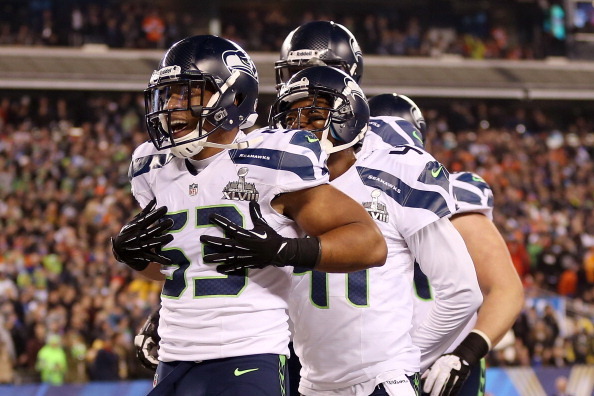 EAST RUTHERFORD, NJ - FEBRUARY 02:  Outside linebacker Malcolm Smith #53 of the Seattle Seahawks celebrates his 69-yard touchdown with teammates after intercepting a pass thrown by quarterback Peyton Manning #18 of the Denver Broncos intended for running 