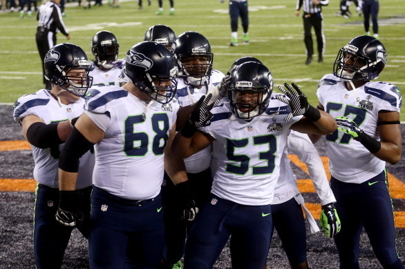 EAST RUTHERFORD, NJ - FEBRUARY 02:  Outside linebacker Malcolm Smith #53 of the Seattle Seahawks celebrates his 69-yard touchdown with teammates after intercepting a pass thrown by quarterback Peyton Manning #18 of the Denver Broncos intended for running 