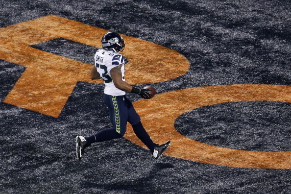 EAST RUTHERFORD, NJ - FEBRUARY 02:  Outside linebacker Malcolm Smith #53 of the Seattle Seahawks runs back an interception for 69 yards off quarterback Peyton Manning of the Denver Broncos during the second quarter of Super Bowl XLVIII at MetLife Stadium 