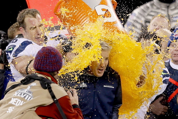 EAST RUTHERFORD, NJ - FEBRUARY 02:  Tight end Zach Miller #86 and quarterback Russell Wilson #3 of the Seattle Seahawks dump Gatorade on head coach Pete Carroll in the fourth quarter of Super Bowl XLVIII against the Denver Broncos at MetLife Stadium on Fe