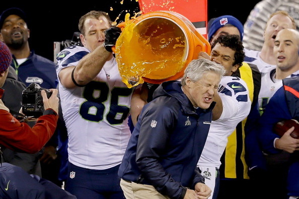 EAST RUTHERFORD, NJ - FEBRUARY 02:  Tight end Zach Miller #86 and quarterback Russell Wilson #3 of the Seattle Seahawks dump Gatorade on head coach Pete Carroll in the fourth quarter of Super Bowl XLVIII against the Denver Broncos at MetLife Stadium on Fe