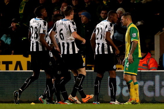 NORWICH, ENGLAND - JANUARY 28:  Shola Ameobi of Newcastle confronts Bradley Johnson of Norwich during the Barclays Premier League match between Norwich City and Newcastle United at Carrow Road on January 28, 2014 in Norwich, England.  (Photo by Scott Heav