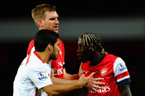 LONDON, ENGLAND - NOVEMBER 02:  Per Mertesacker of Arsenal holds back Bacary Sagna of Arsenal as he clashes with Luis Suarez of Liverpool during the Barclays Premier League match between Arsenal and Liverpool at Emirates Stadium on November 2, 2013 in Lon