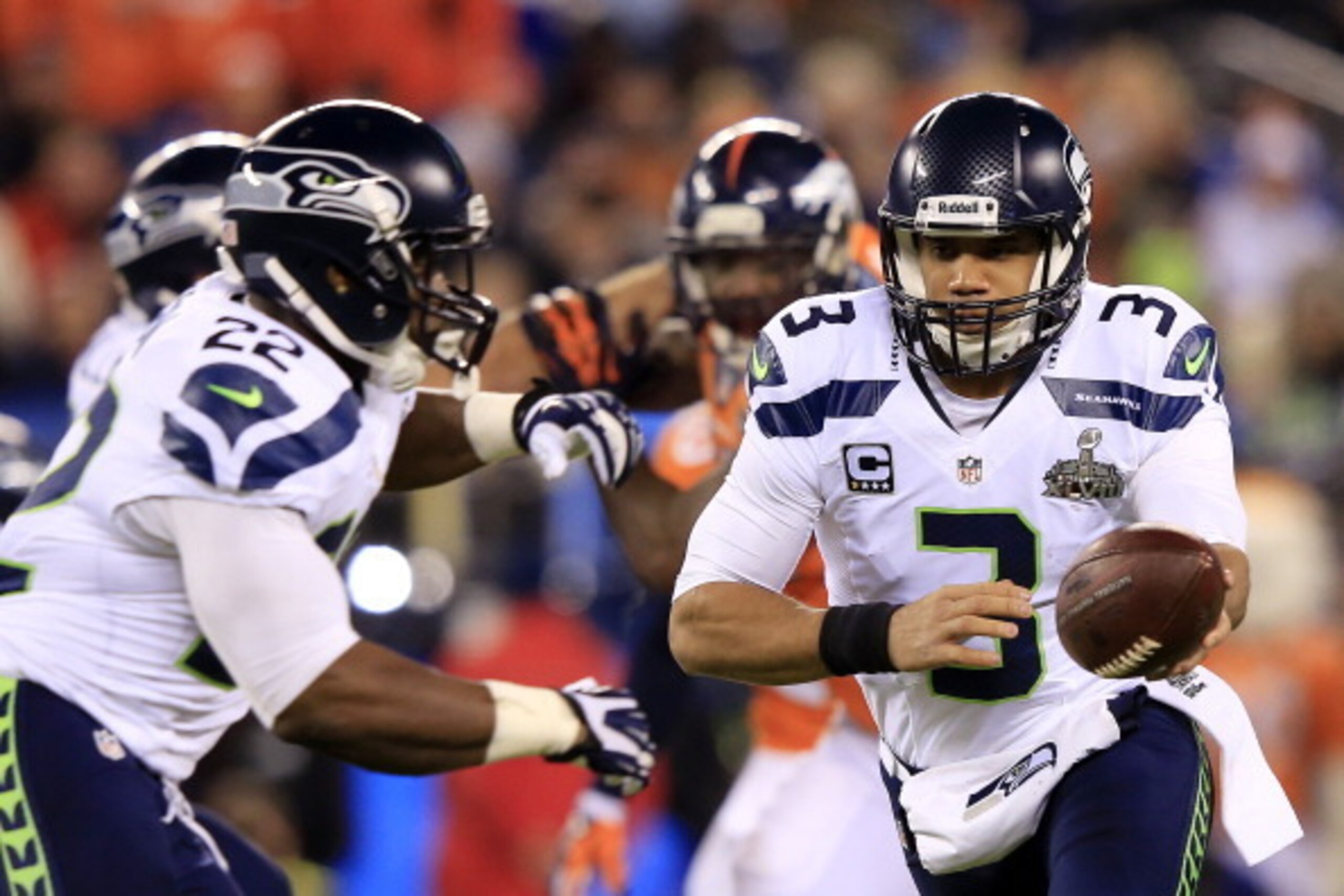 EAST RUTHERFORD, NJ - FEBRUARY 02:  Quarterback Russell Wilson #3 of the Seattle Seahawks looks to hand off the ball to teammate running back Robert Turbin #22 during Super Bowl XLVIII against the Denver Broncos at MetLife Stadium on February 2, 2014 in E