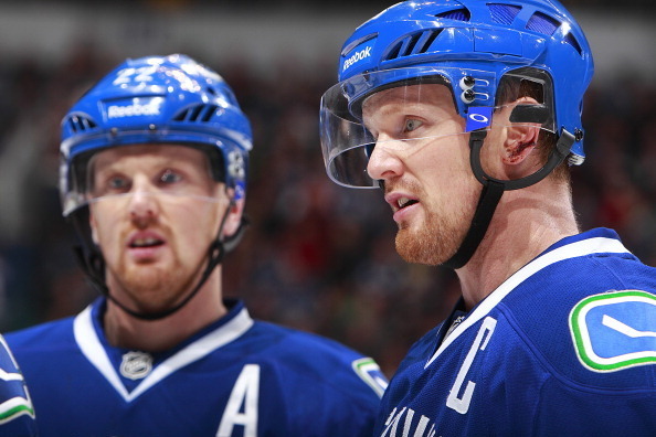VANCOUVER, BC - DECEMBER 30:  Henrik Sedin #33 and Daniel Sedin #22 of the Vancouver Canucks talk during their NHL game against the Philadelphia Flyers at Rogers Arena December 30, 2013 in Vancouver, British Columbia, Canada.  Philadelphia won 4-3 in a sh
