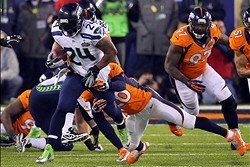 Feb 2, 2014; East Rutherford, NJ, USA; Seattle Seahawks running back Marshawn Lynch (24) runs the ball against Denver Broncos free safety Mike Adams (20) during the second half in Super Bowl XLVIII at MetLife Stadium.  Mandatory Credit: Adam Hunger-USA TO