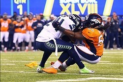 Feb 2, 2014; East Rutherford, NJ, USA; Seattle Seahawks running back Marshawn Lynch (24) is tackled by Denver Broncos outside linebacker Nate Irving (56) in Super Bowl XLVIII at MetLife Stadium.  Mandatory Credit: Mark J. Rebilas-USA TODAY Sports